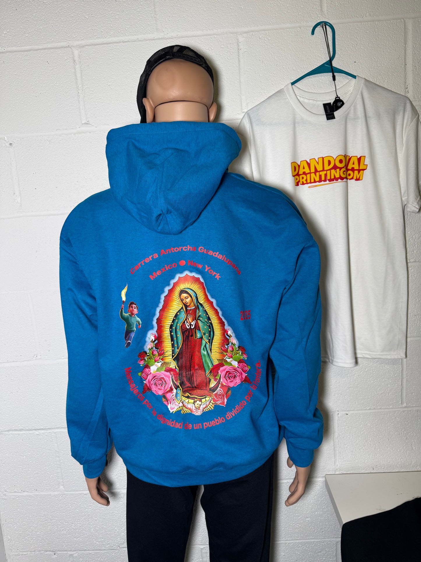 Blue hoodie with a colorful graphic design on a tiled floor.