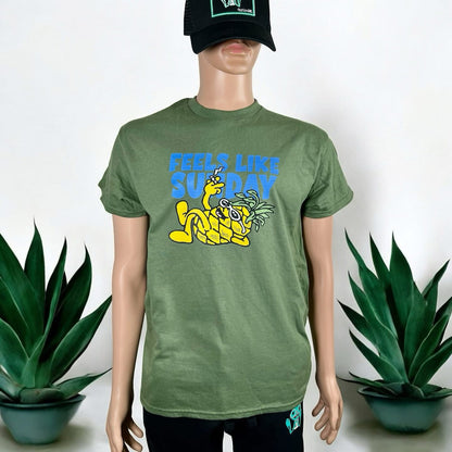 Mannequin wearing a green t-shirt with a graphic design and text, standing against a white background with plants.