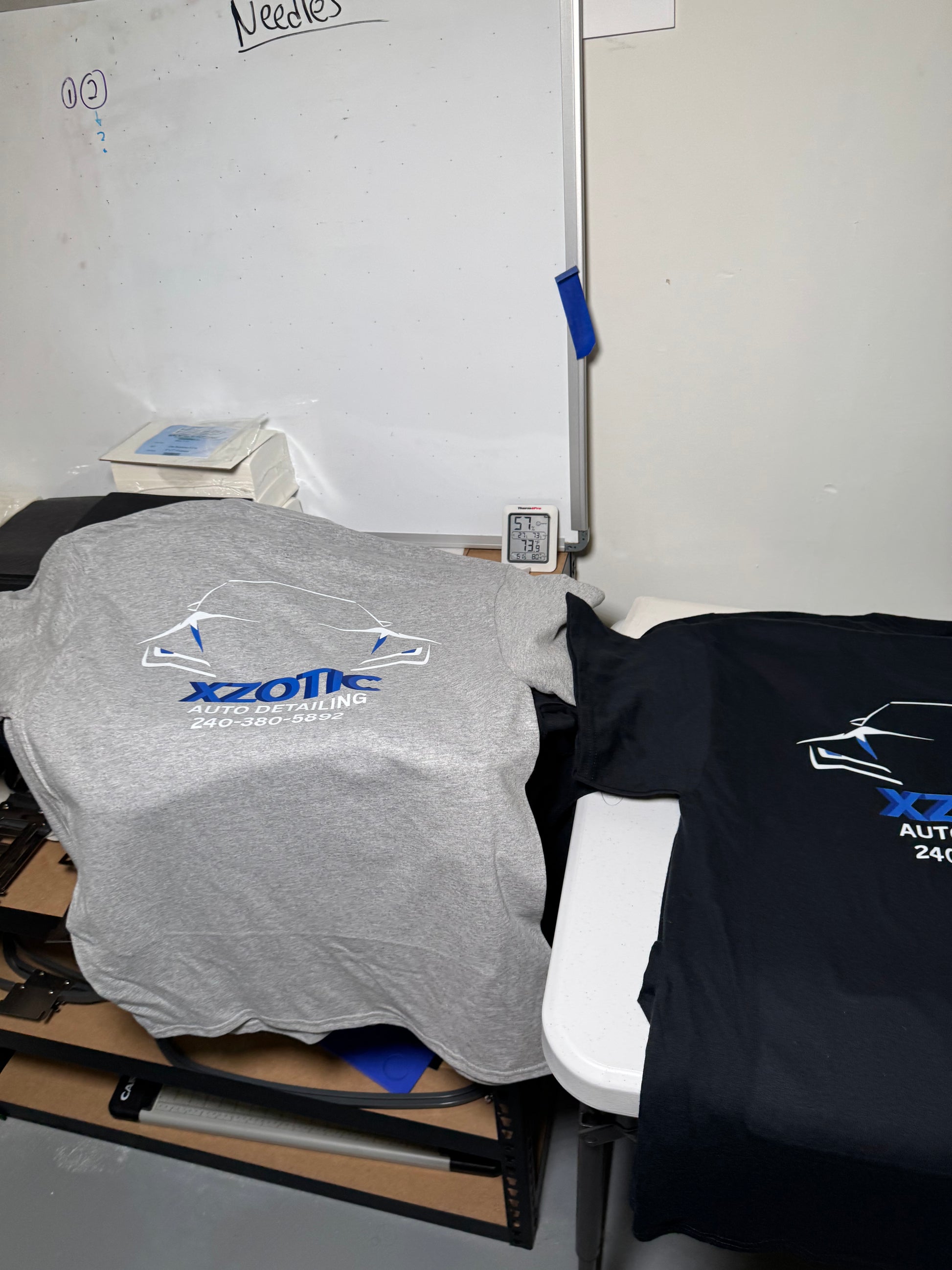 Person wearing a black hoodie and gray pants with a visible brand logo, standing in a room.