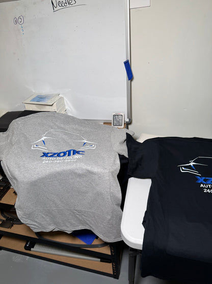 Person wearing a black hoodie and gray pants with a visible brand logo, standing in a room.