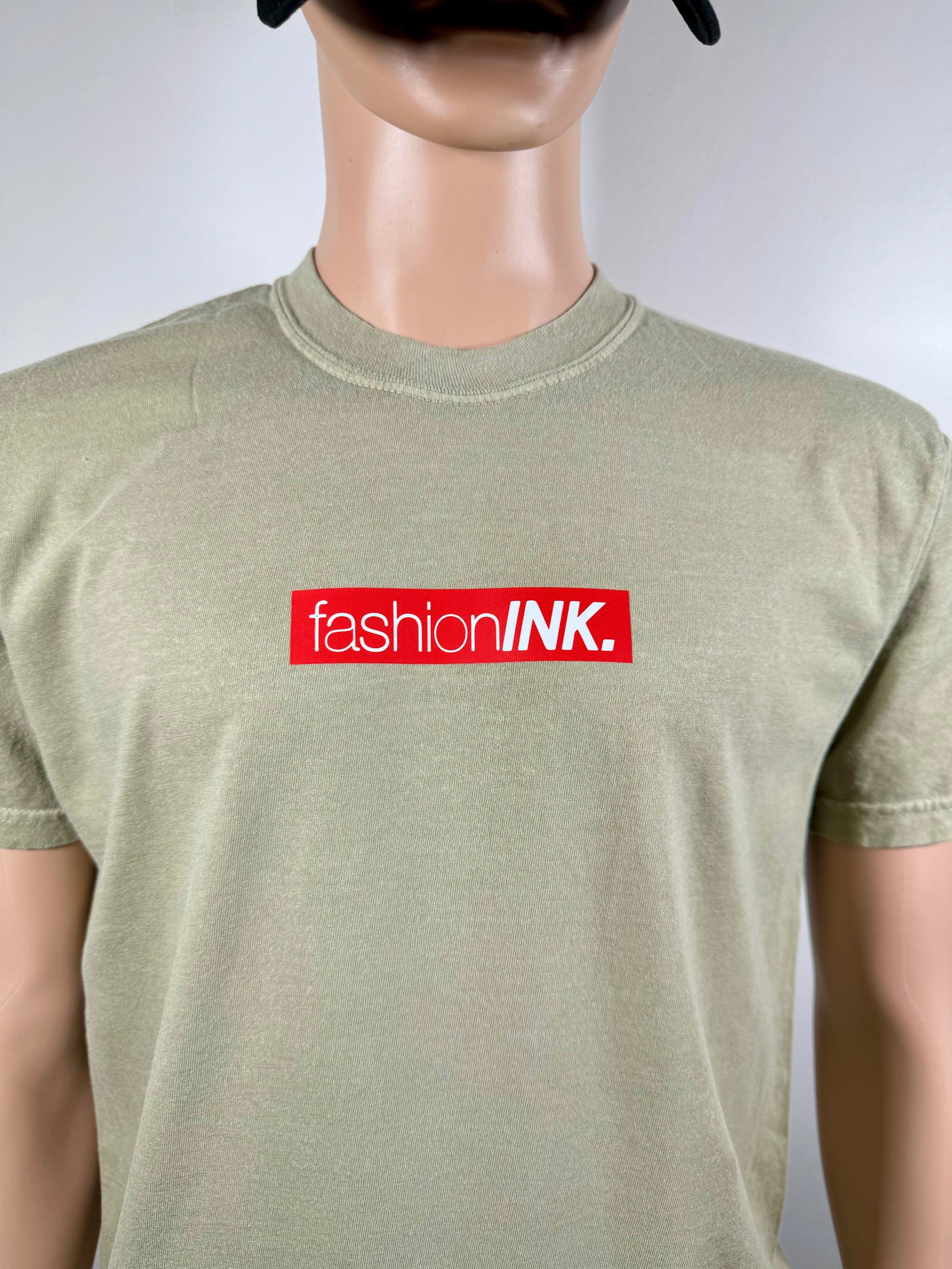Mannequin wearing a green t-shirt with 'fashionINK.' logo on a white background
