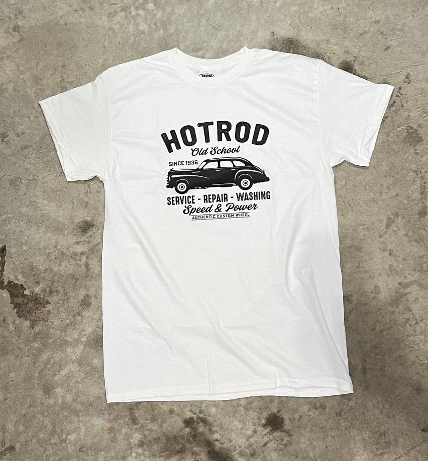 White t-shirt with black graphic design on a concrete surface