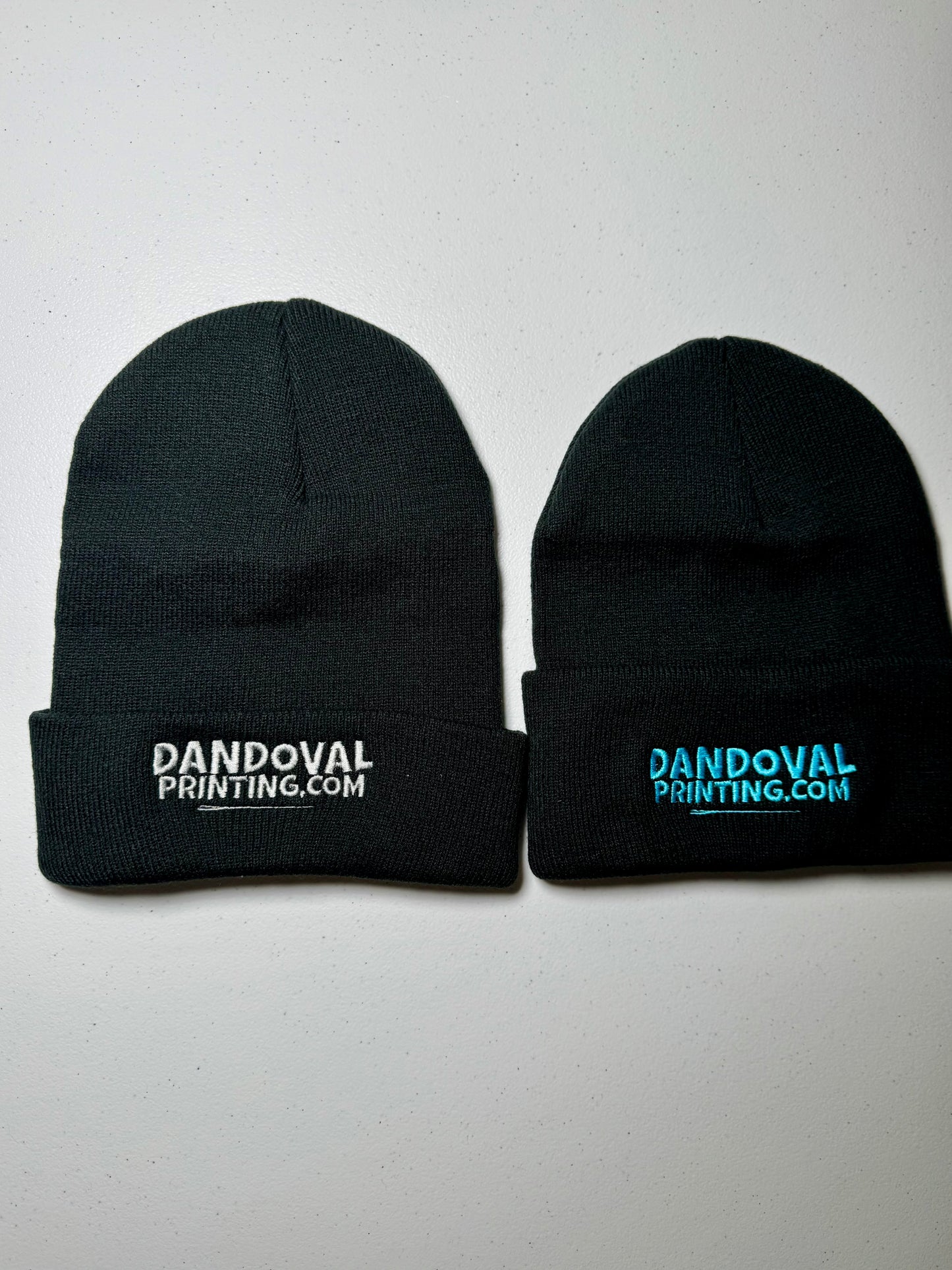 Two black beanie hats with 'Dandoval Printing.com' text on a white background