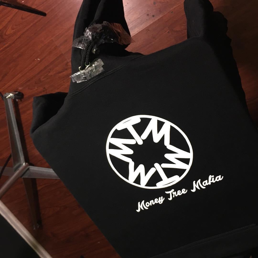 Black bag with a white logo and text on a wooden floor