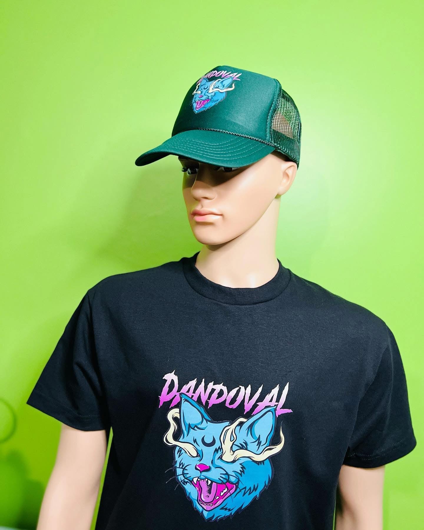 Mannequin wearing a black t-shirt with a colorful graphic design and a green cap on a green background