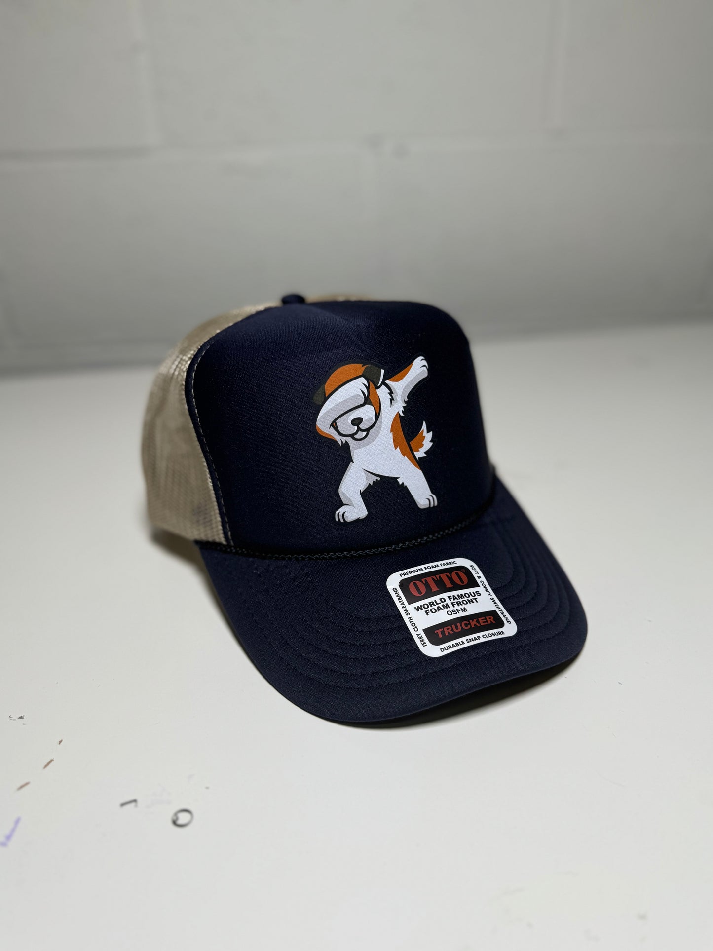 Navy blue cap with cartoon dog design on a white surface