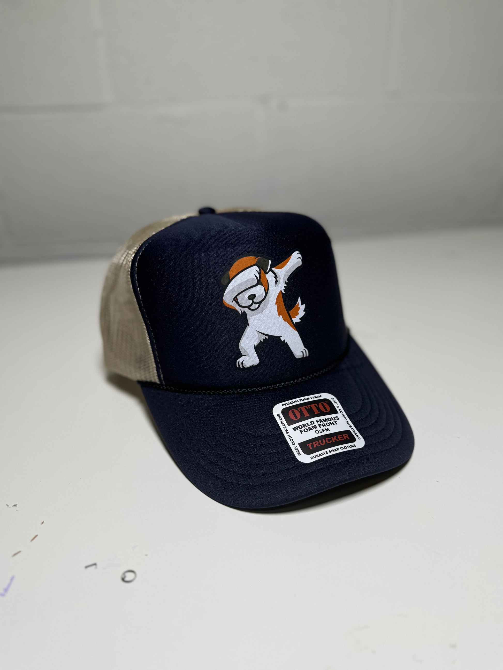 Navy blue cap with cartoon dog design on a white surface
