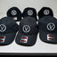 Black baseball caps with a logo and brand label on a white surface