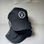 Black cap with a white logo on a light gray background