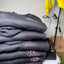 Stack of gray hoodies with 'Maddox's Cleaning' logo on a white surface.