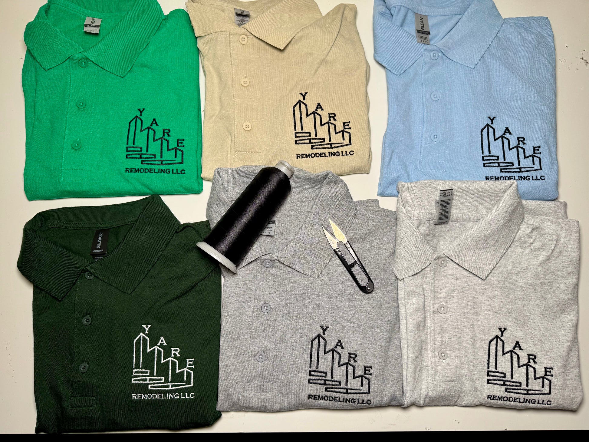 Collection of folded polo shirts with Yare Remodeling LLC logo on a light background