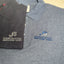Two polo shirts with embroidered logos on a flat surface