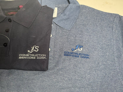 Two polo shirts with embroidered logos on a flat surface