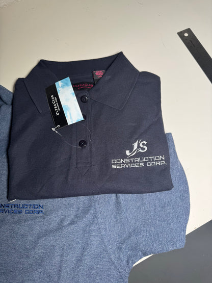 Folded navy blue shirt with a logo and tag on a gray surface