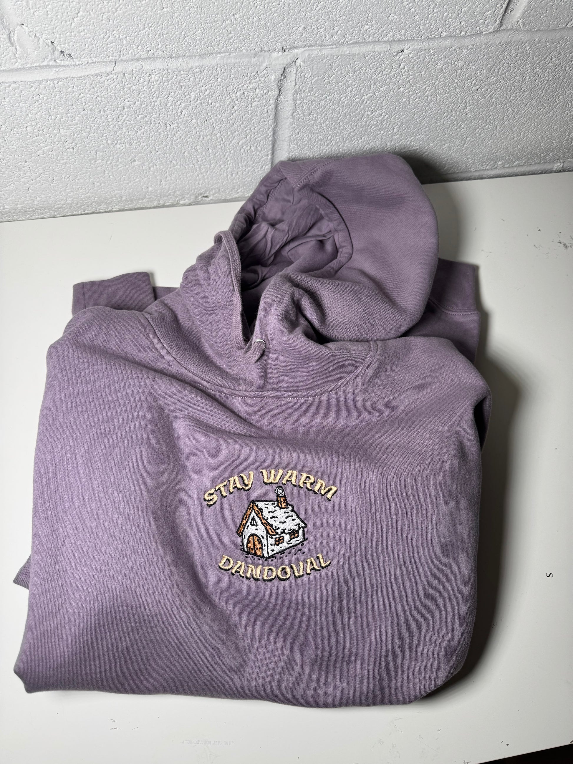 Purple hoodie with a logo on a white surface