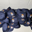 Stack of navy blue caps with logos on a white tiled floor