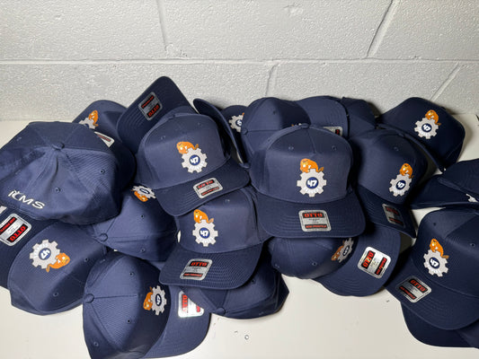 Stack of navy blue caps with logos on a white tiled floor